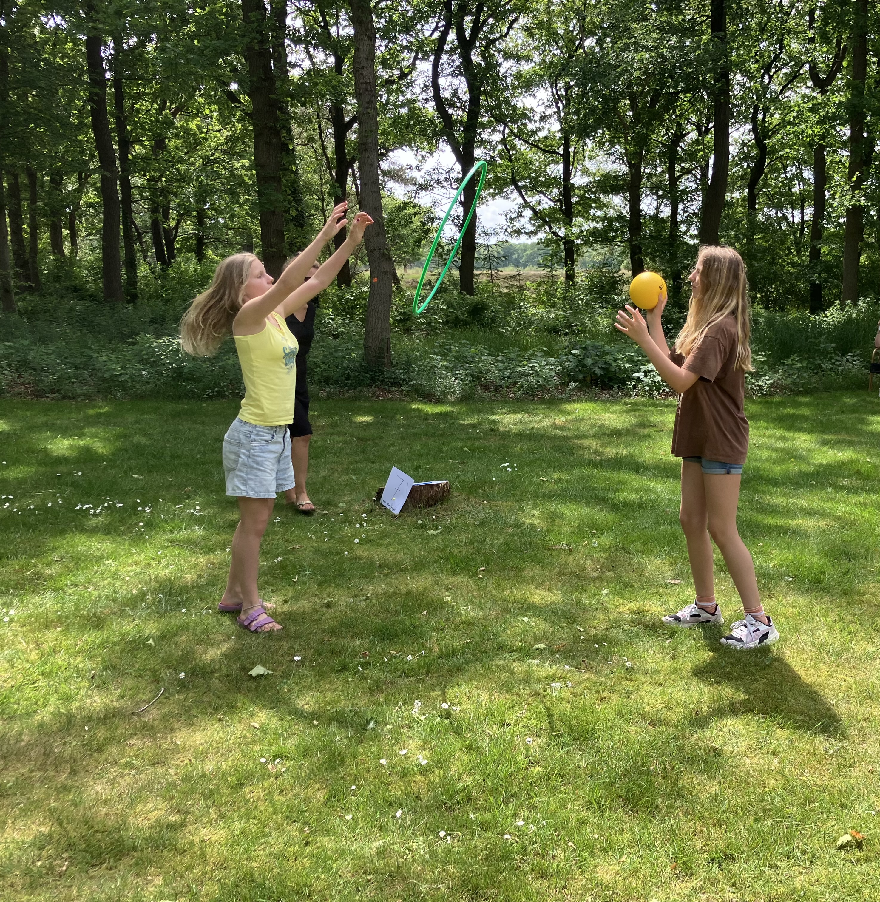 Twee kinderen gooien buiten een bal naar elkaar over