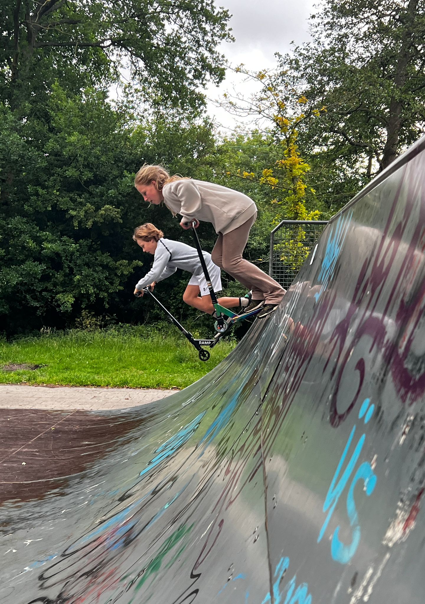 Kinderen steppen samen door de straat